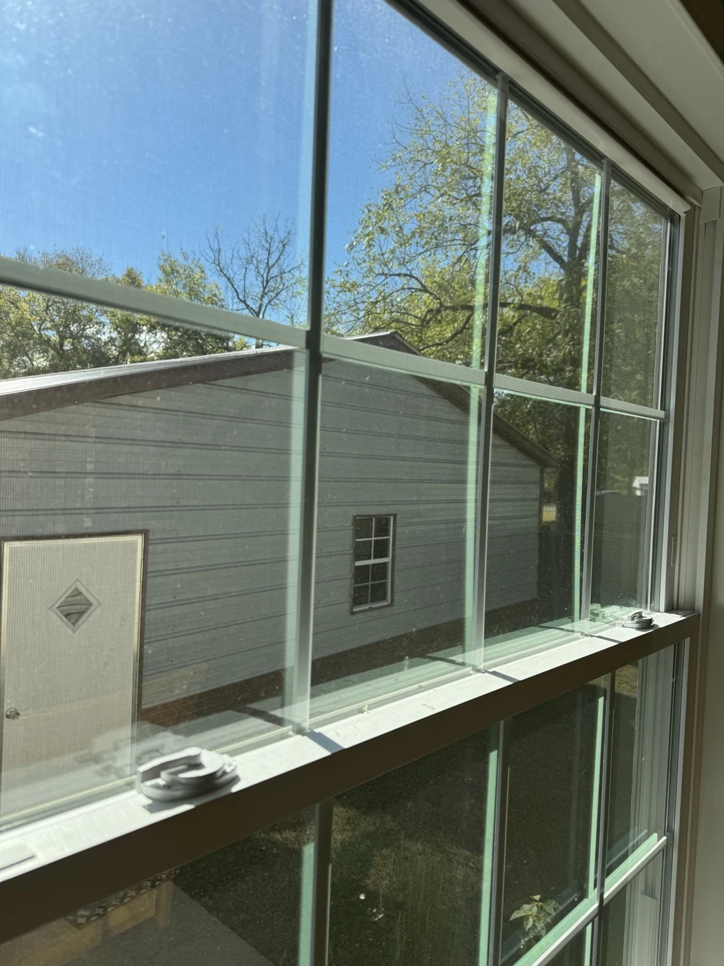 Before cleaning: residential window glass with visible spots and haze